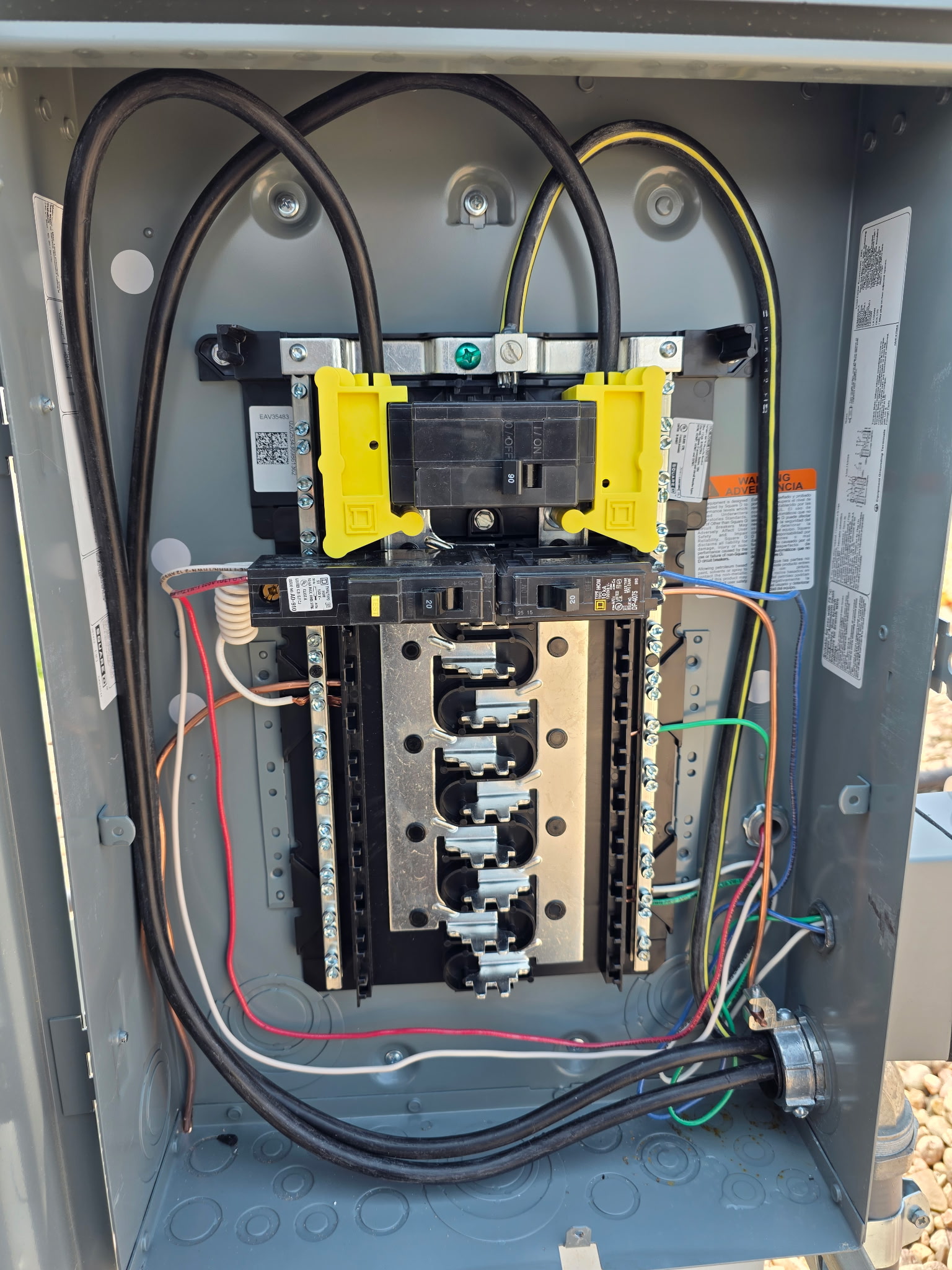 Open electrical panel showing wiring, circuit breaker, bus bars, and terminal connections inside a metal enclosure.
